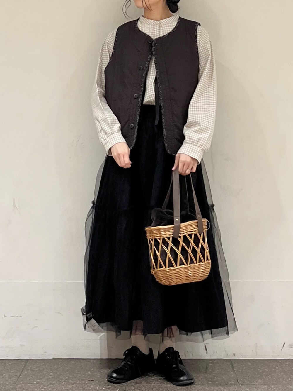 ベージュ系のシャツ/ブラウス、ブラック系のベスト、ブラック系のスカートを着用したレディースの冬コーディネートの2枚目の写真