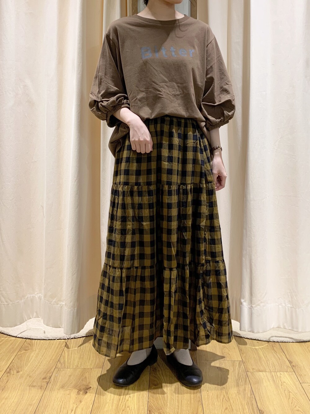 ブラウン系のTシャツ/カットソー、グレー系のベスト、イエロー系のスカートを着用したレディースの夏コーディネートの5枚目の写真