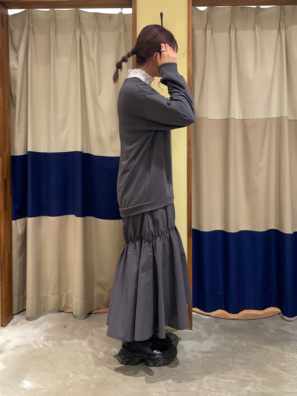 パープル系のハンドバッグ、グレー系のワンピースを着用したレディースの秋コーディネートの3枚目の写真