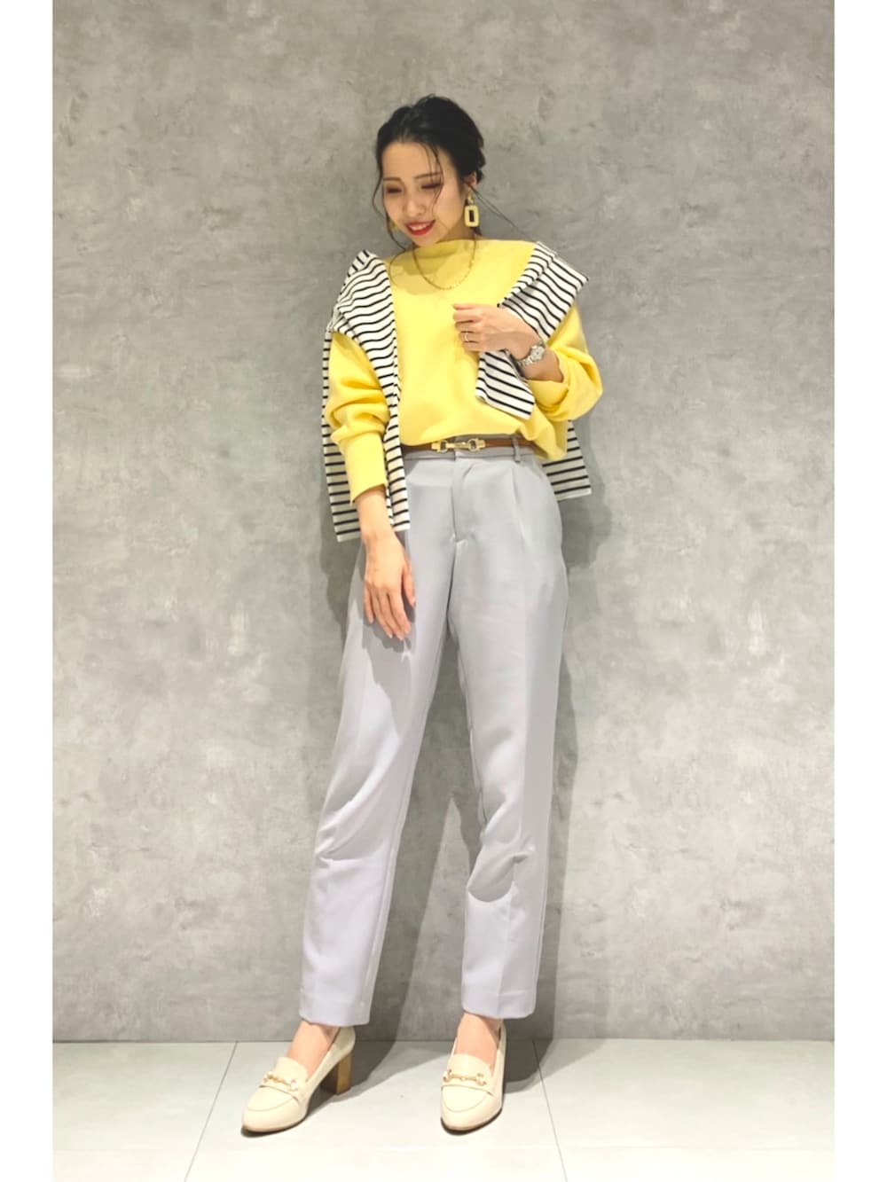 イエロー系のニット/セーター、ブルー系のその他パンツ、ホワイト系のローファーを着用したレディースの冬コーディネートの2枚目の写真