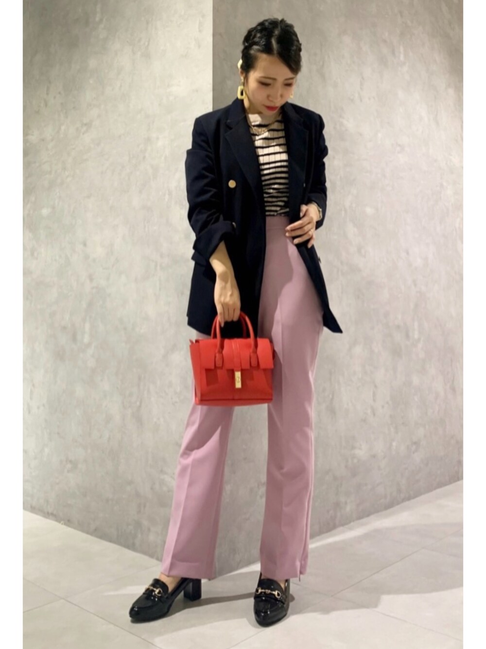 ブルー系のテーラードジャケット、ベージュ系のニット/セーター、レッド系のショルダーバッグを着用したレディースの冬コーディネートの2枚目の写真