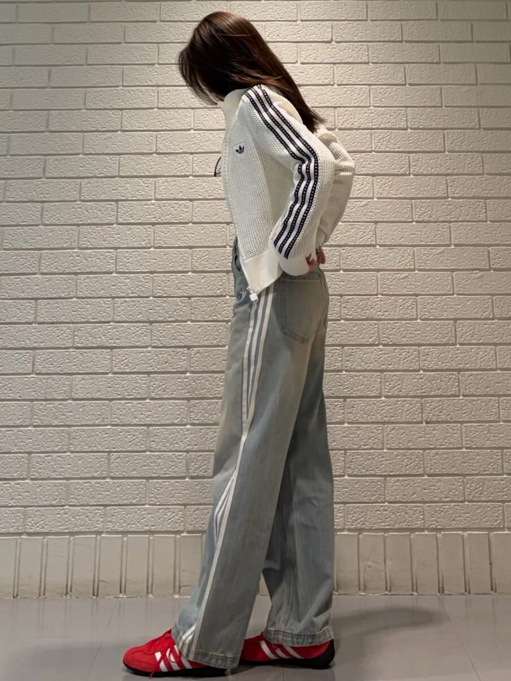 ホワイト系のジャージ、レッド系のスニーカーを着用したレディースの春コーディネートの2枚目の写真