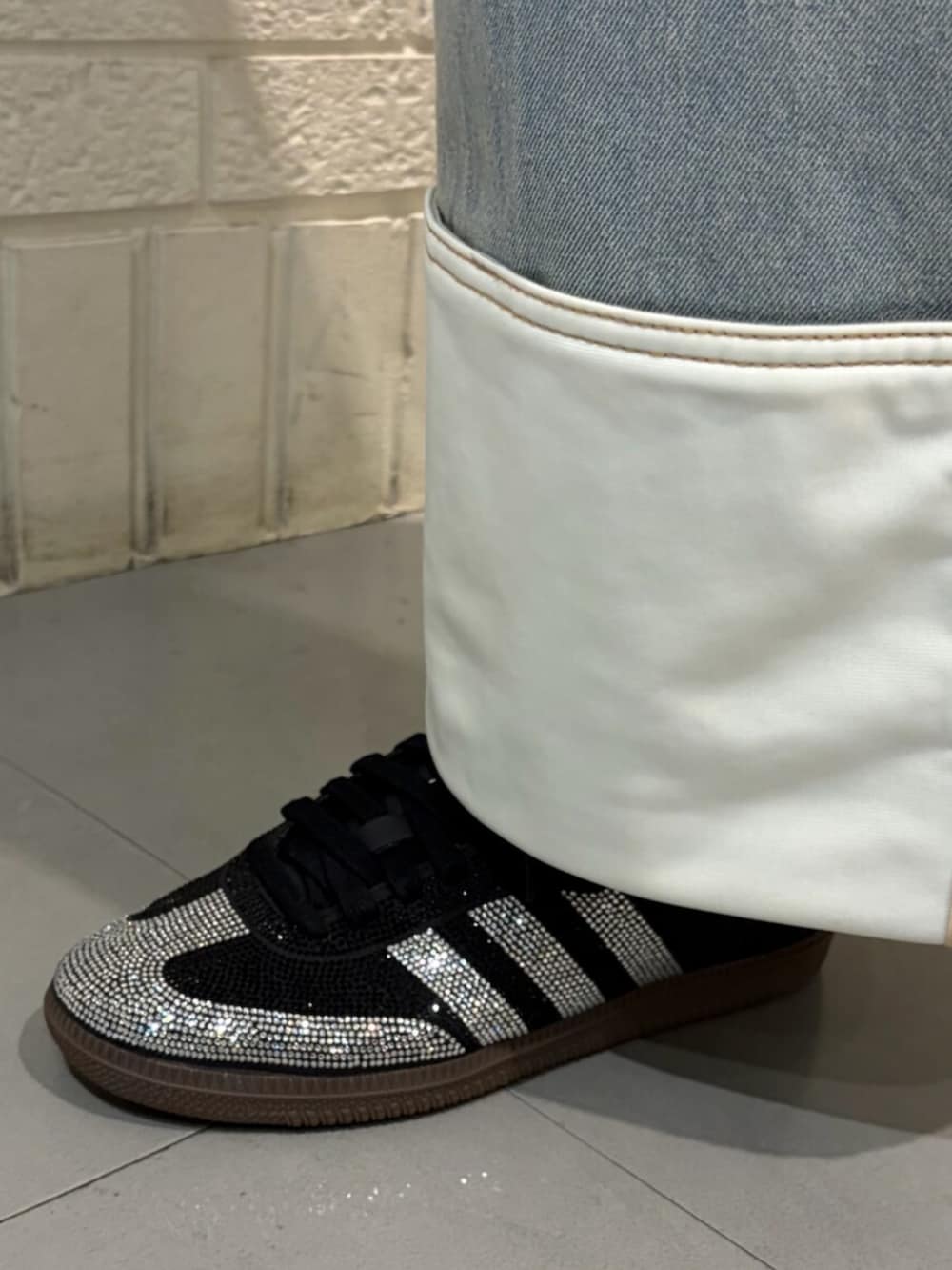 ピンク系のTシャツ/カットソー、ブルー系のデニムパンツ、ブラック系のスニーカーを着用したレディースの春コーディネートの4枚目の写真