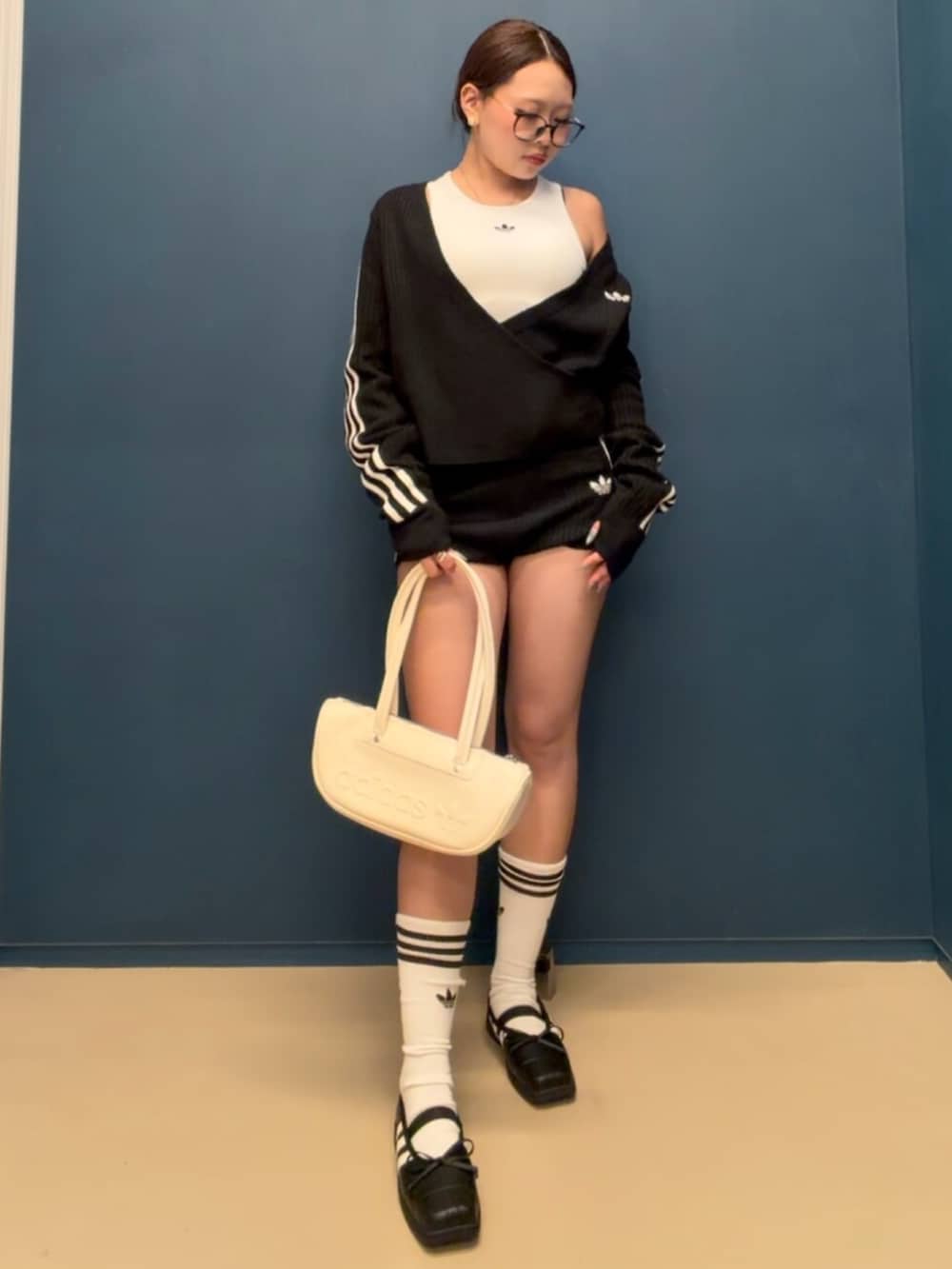 ホワイト系のタンクトップ、ブラック系のカーディガン/ボレロ、ブラック系のパンツを着用したレディースの秋コーディネートの2枚目の写真