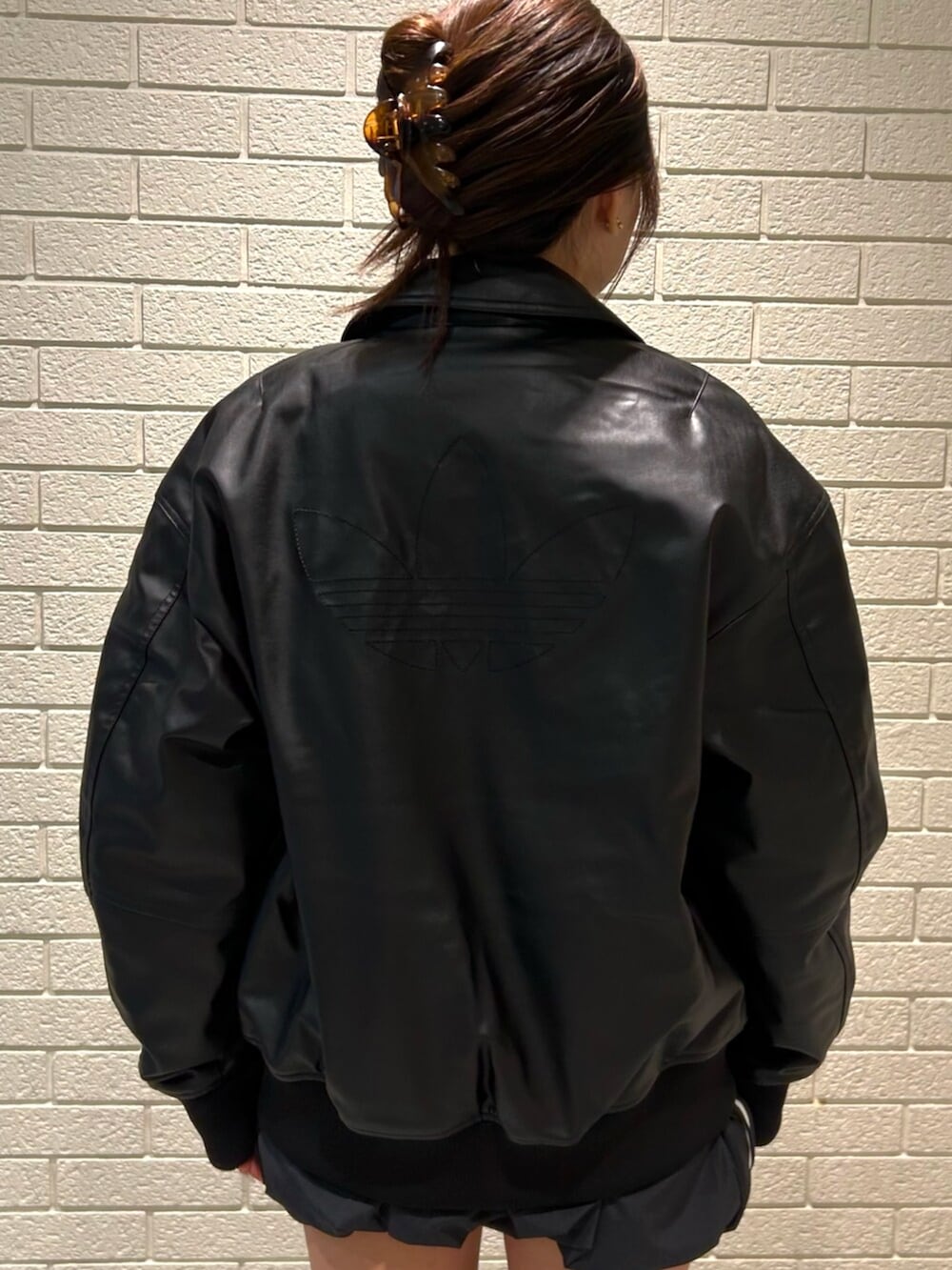 ブラック系のブルゾン、ブラック系のスカートを着用したレディースの冬コーディネートの3枚目の写真