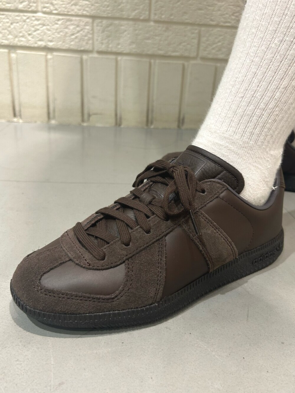 ホワイト系のトップス、ベージュ系のショルダーバッグ、ブラウン系のスニーカーを着用したレディースの夏コーディネートの4枚目の写真
