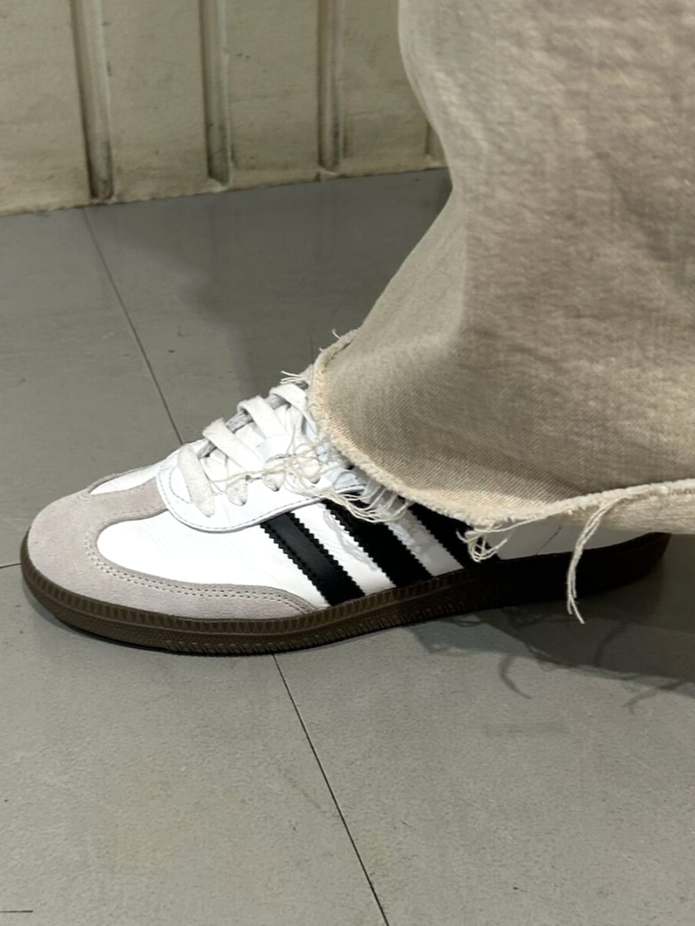 ホワイト系のシューズ、ブラック系のダウンジャケット/コートを着用したレディースの秋コーディネートの4枚目の写真