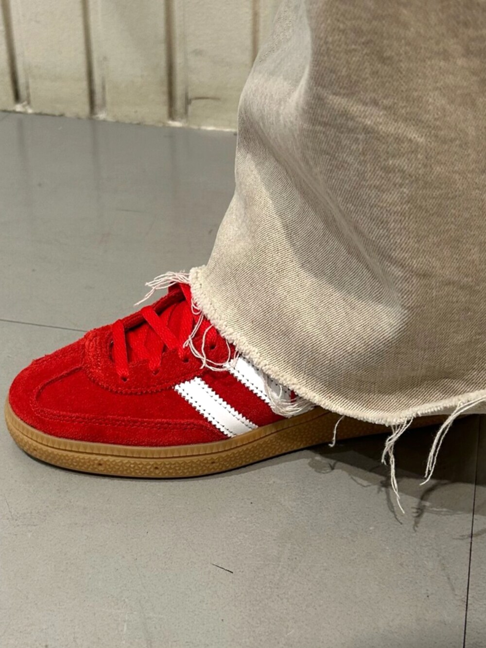 ブラック系のショルダーバッグ、ブラック系のスウェット、レッド系のスニーカーを着用したレディースの秋コーディネートの4枚目の写真