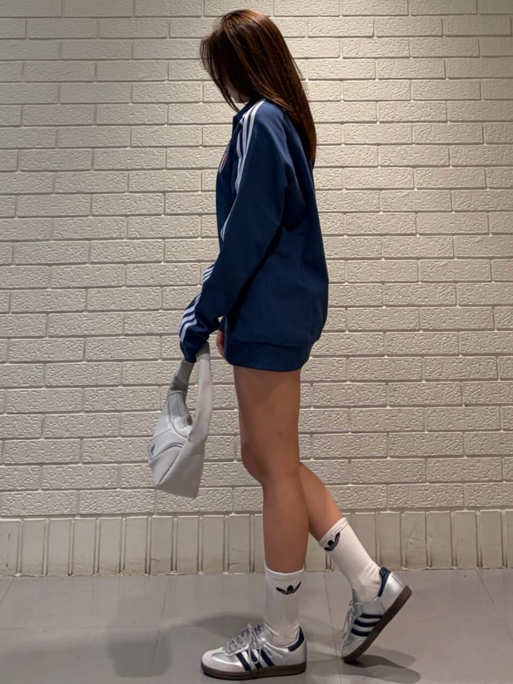 ブルー系のジャージ、シルバー系のスニーカーを着用したレディースの春コーディネートの2枚目の写真