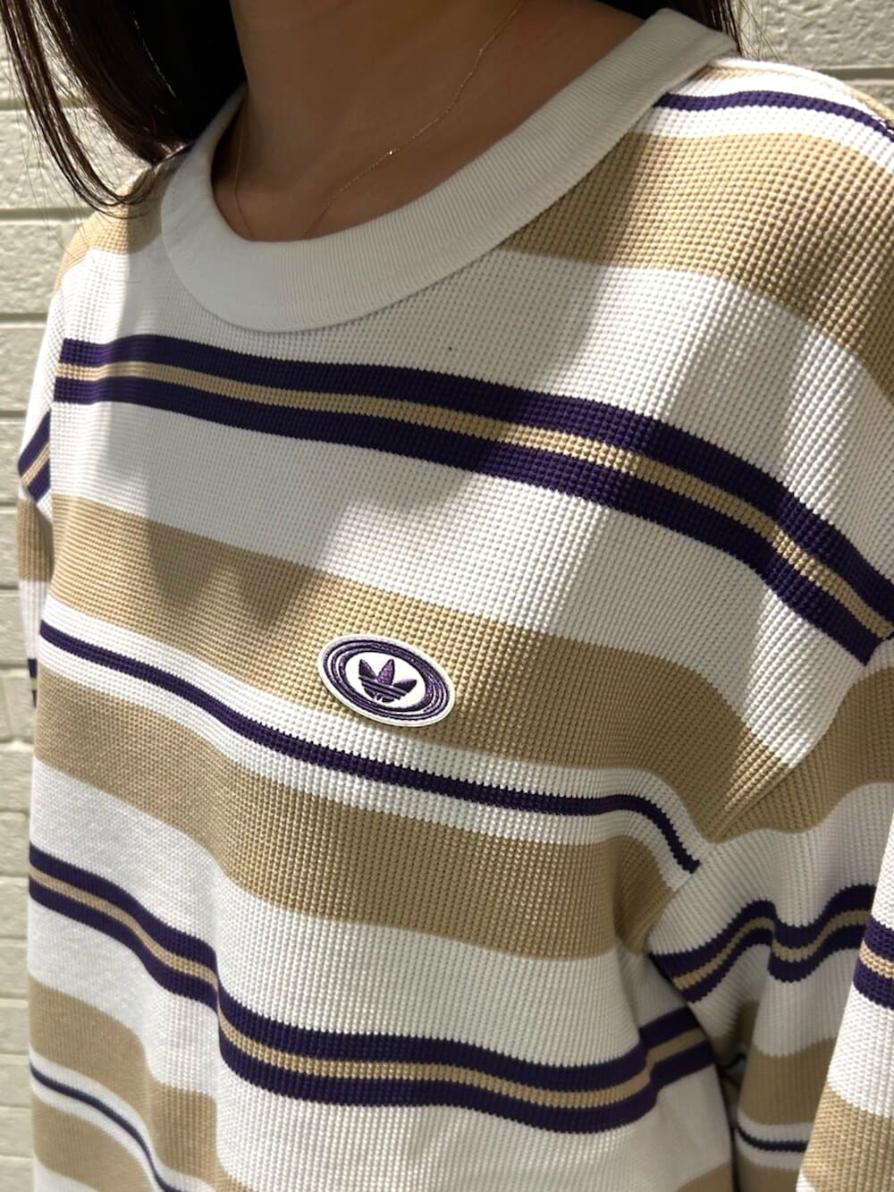 ホワイト系のTシャツ/カットソー、ベージュ系のその他パンツ、ブラウン系のスニーカーを着用したレディースの冬コーディネートの3枚目の写真