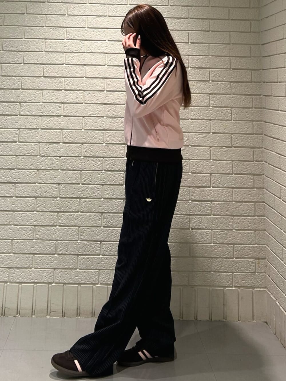 ピンク系のジャージ、ブラック系のスウェットパンツ、ブラウン系のスニーカーを着用したレディースの冬コーディネートの2枚目の写真