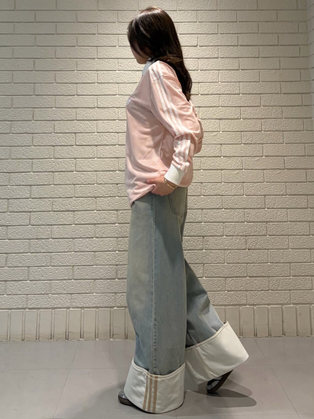 ピンク系のTシャツ/カットソー、ブルー系のデニムパンツ、ブラック系のスニーカーを着用したレディースの春コーディネートの2枚目の写真