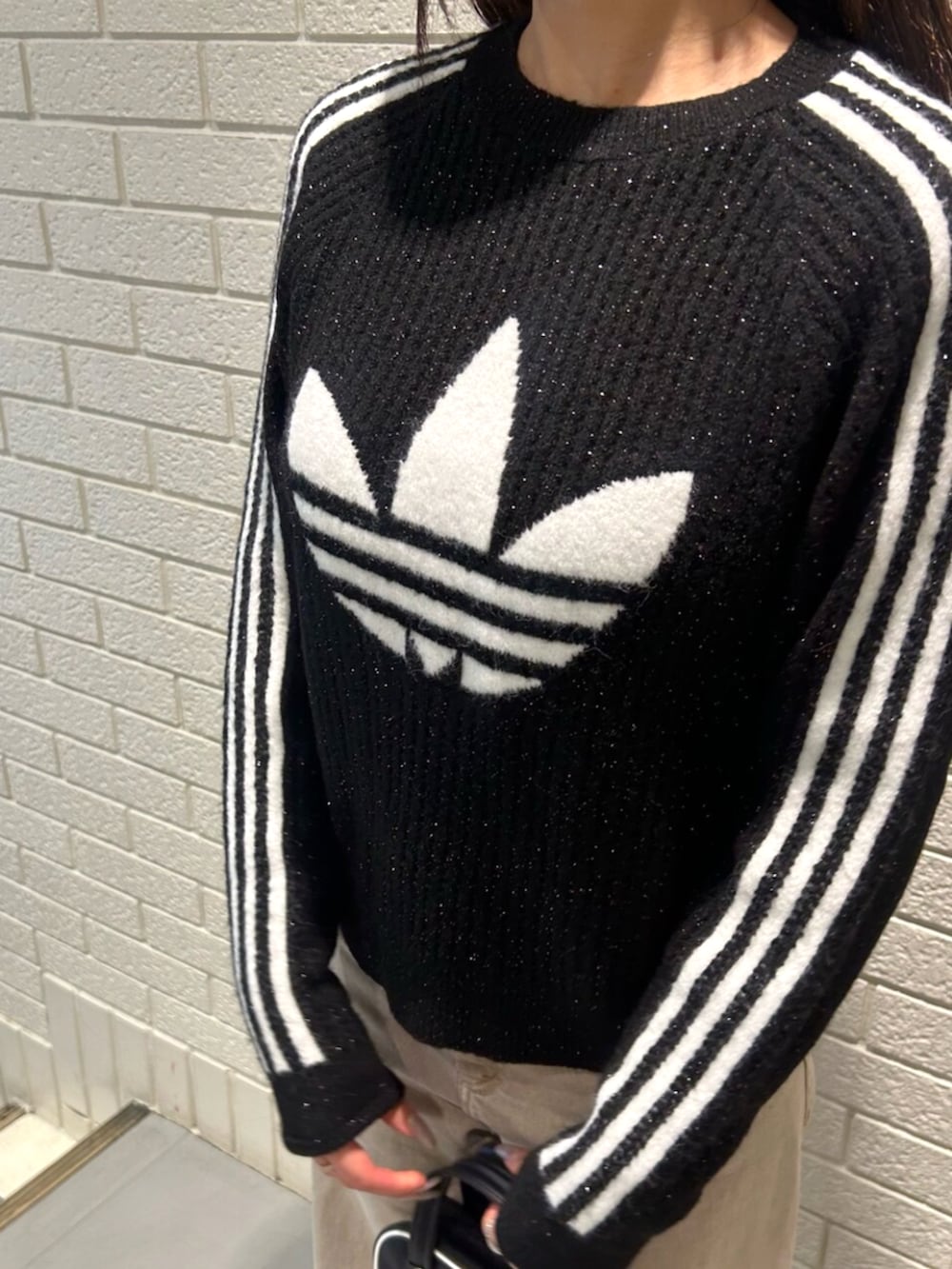 ブラック系のショルダーバッグ、ブラック系のスウェット、レッド系のスニーカーを着用したレディースの秋コーディネートの3枚目の写真