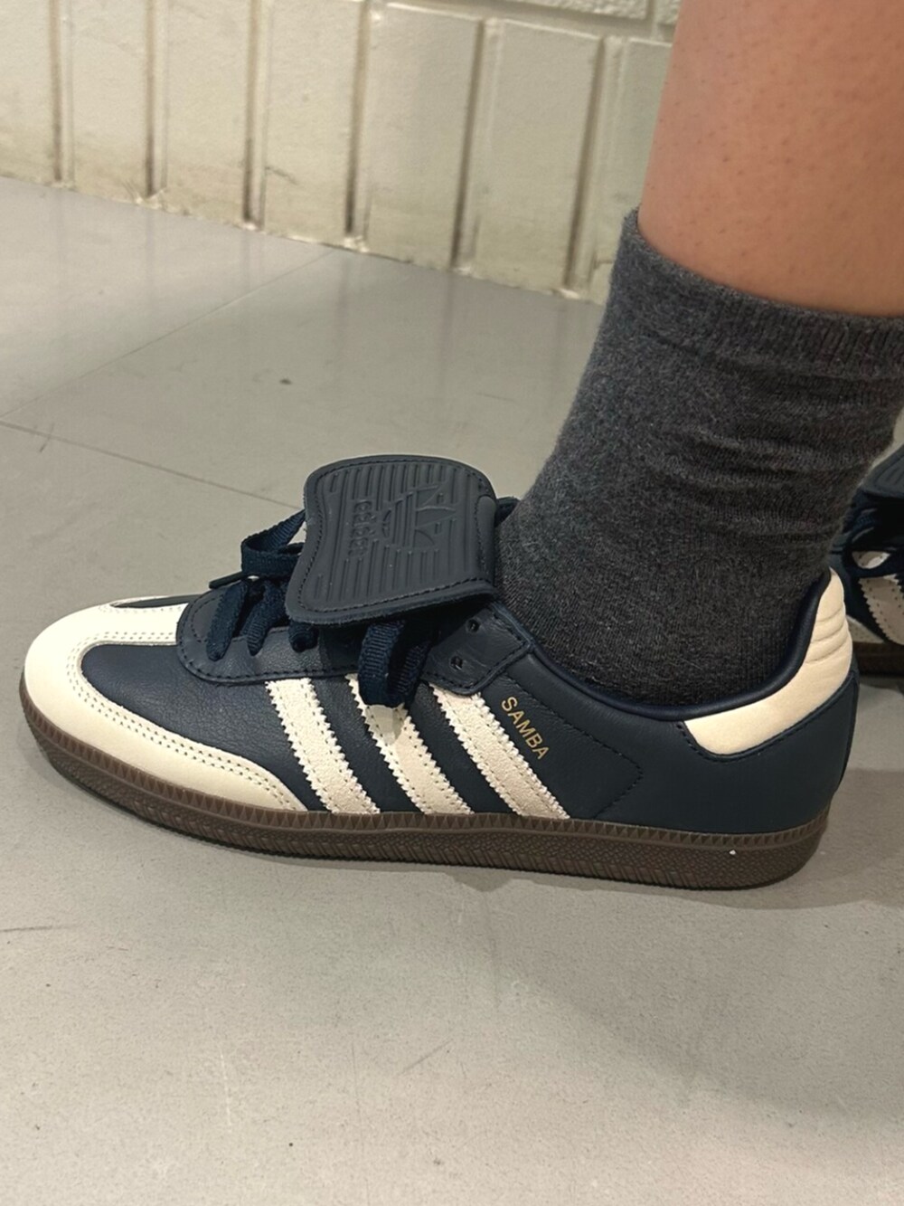 ホワイト系のポロシャツ、ブルー系のスニーカーを着用したレディースの夏コーディネートの4枚目の写真