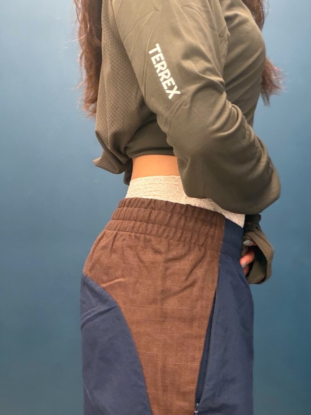 ホワイト系のシューズ、ブルー系のパンツ、グリーン系のトップスを着用したレディースの秋コーディネートの2枚目の写真