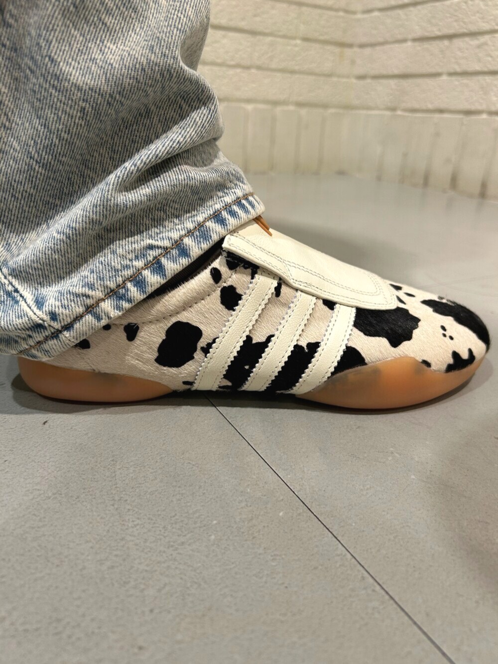 ホワイト系のシューズ、ブラック系のトップス、グリーン系のショルダーバッグを着用したレディースの春コーディネートの4枚目の写真