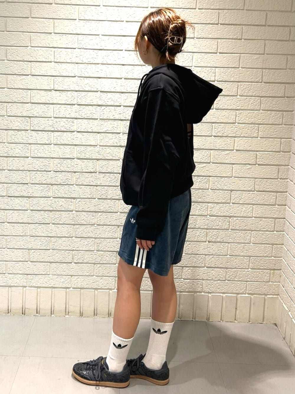 ブラック系のパーカー、ブラック系のスニーカー、グリーン系のその他パンツを着用したレディースの秋コーディネートの2枚目の写真