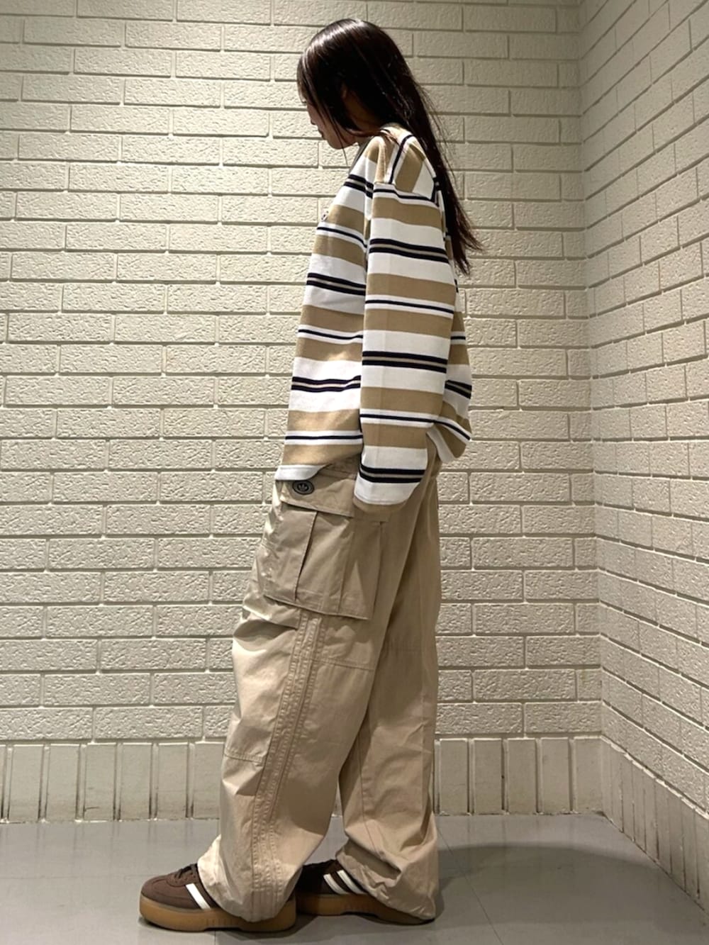 ホワイト系のTシャツ/カットソー、ベージュ系のその他パンツ、ブラウン系のスニーカーを着用したレディースの冬コーディネートの2枚目の写真