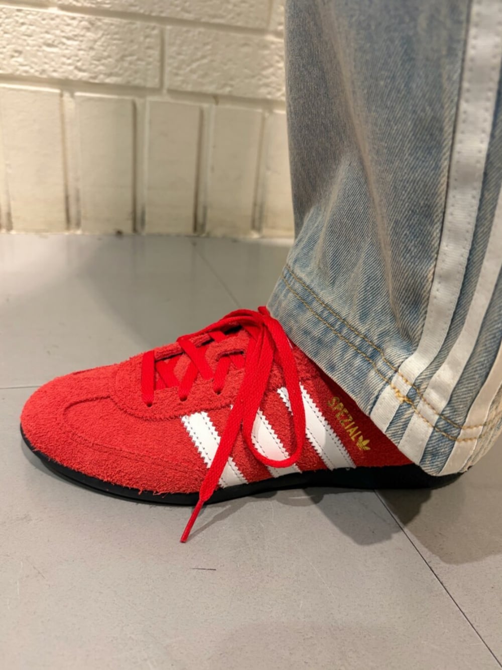 ホワイト系のジャージ、レッド系のスニーカーを着用したレディースの春コーディネートの4枚目の写真