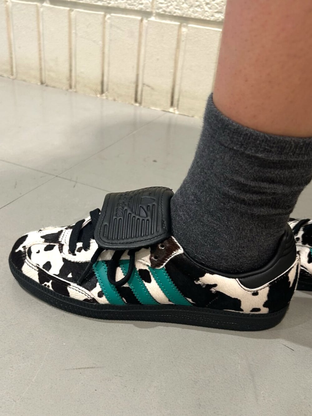 グレー系のデニムスカート、ブラック系のスニーカーを着用したレディースの夏コーディネートの2枚目の写真