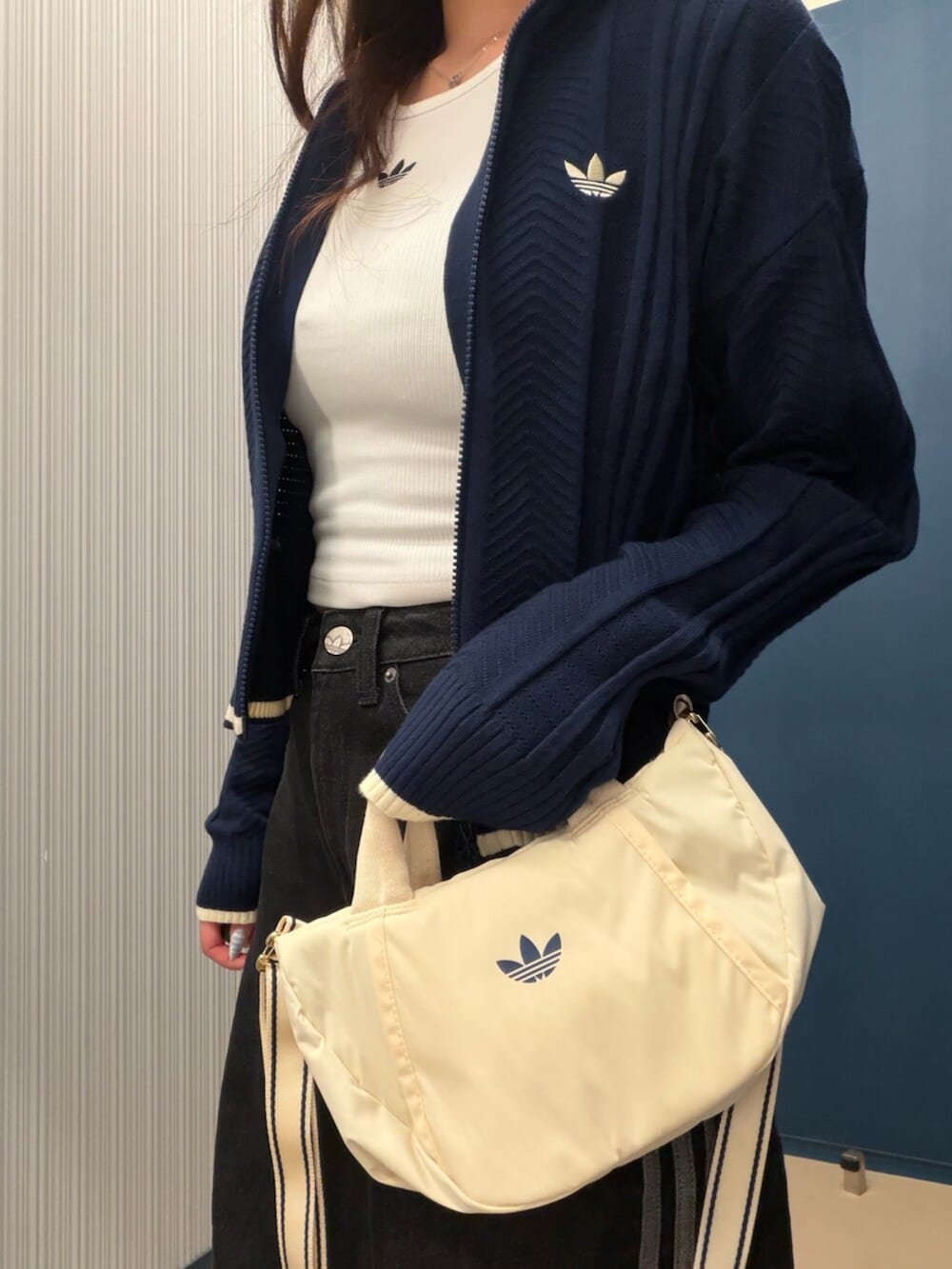 ベージュ系のスニーカー、ブルー系のジャージ、ブラック系のデニムパンツを着用したレディースの夏コーディネートの2枚目の写真