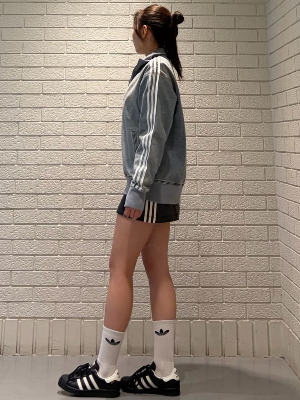 ブラック系のシューズ、ブルー系のデニムジャケット、ブラック系のスカートを着用したレディースの春コーディネートの2枚目の写真