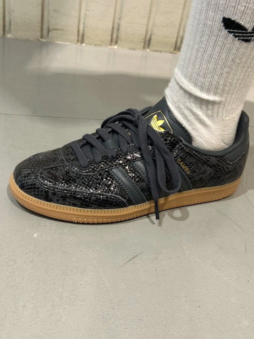 ブラック系のパーカー、ブラック系のスニーカー、グリーン系のその他パンツを着用したレディースの秋コーディネートの4枚目の写真