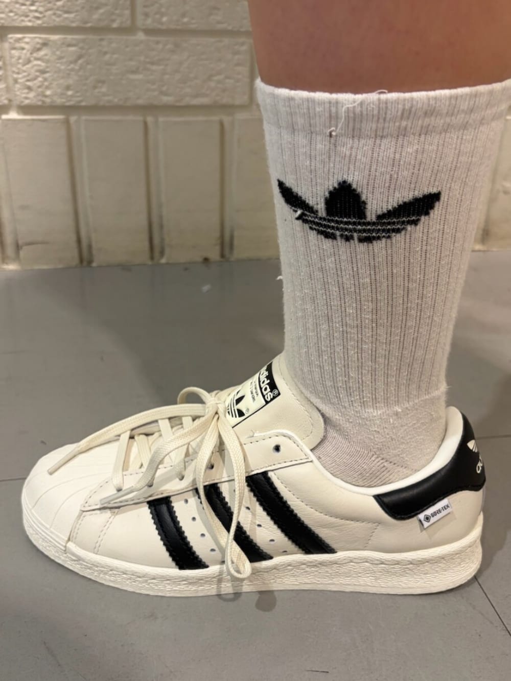 ブラック系のジャージ、ピンク系のその他パンツ、ホワイト系のシューズを着用したレディースの春コーディネートの4枚目の写真