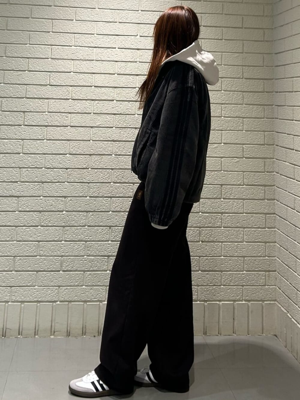 ホワイト系のシューズ、ブラック系のトップスを着用したレディースの冬コーディネートの2枚目の写真