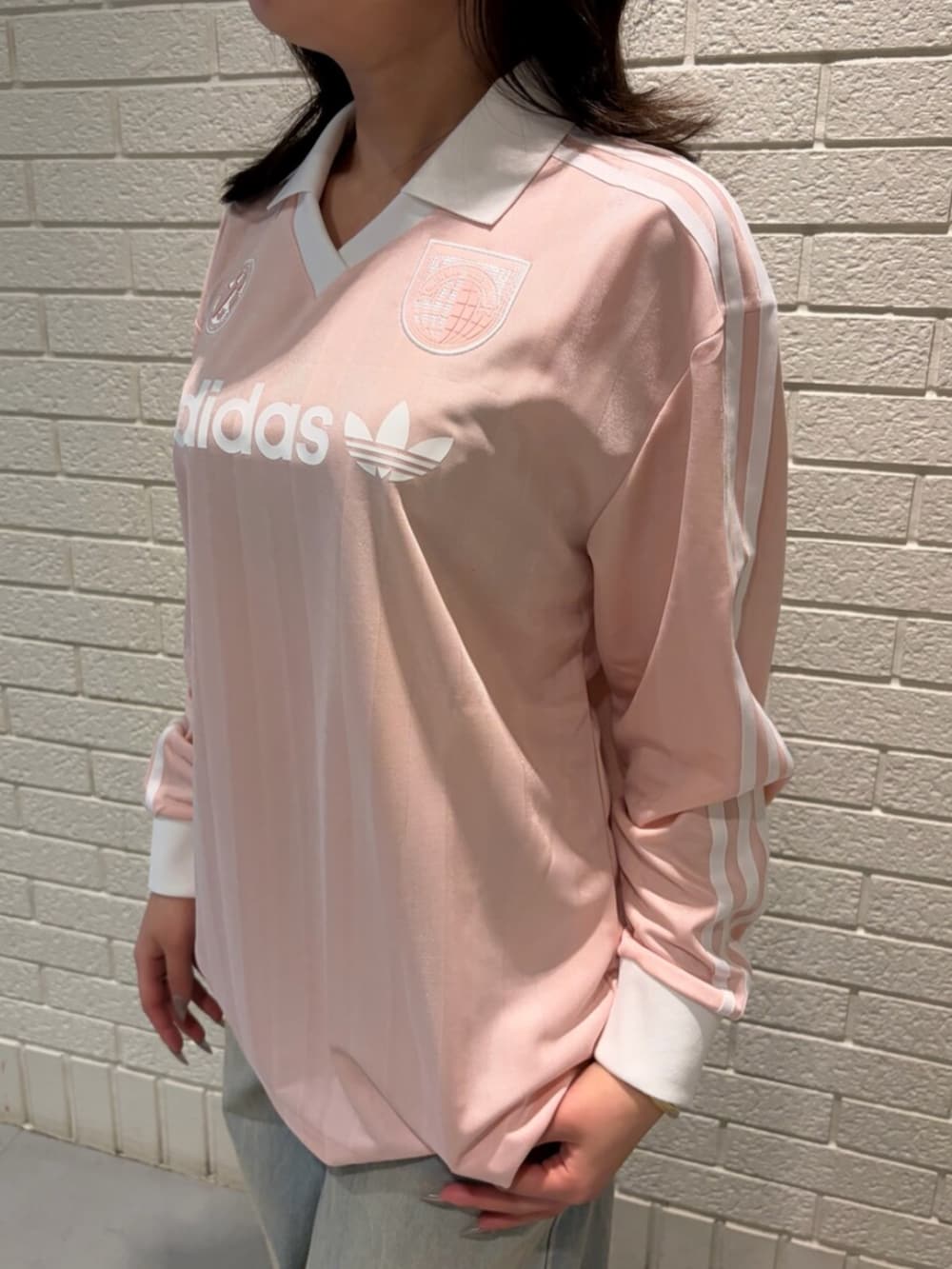 ピンク系のTシャツ/カットソー、ブルー系のデニムパンツ、ブラック系のスニーカーを着用したレディースの春コーディネートの3枚目の写真