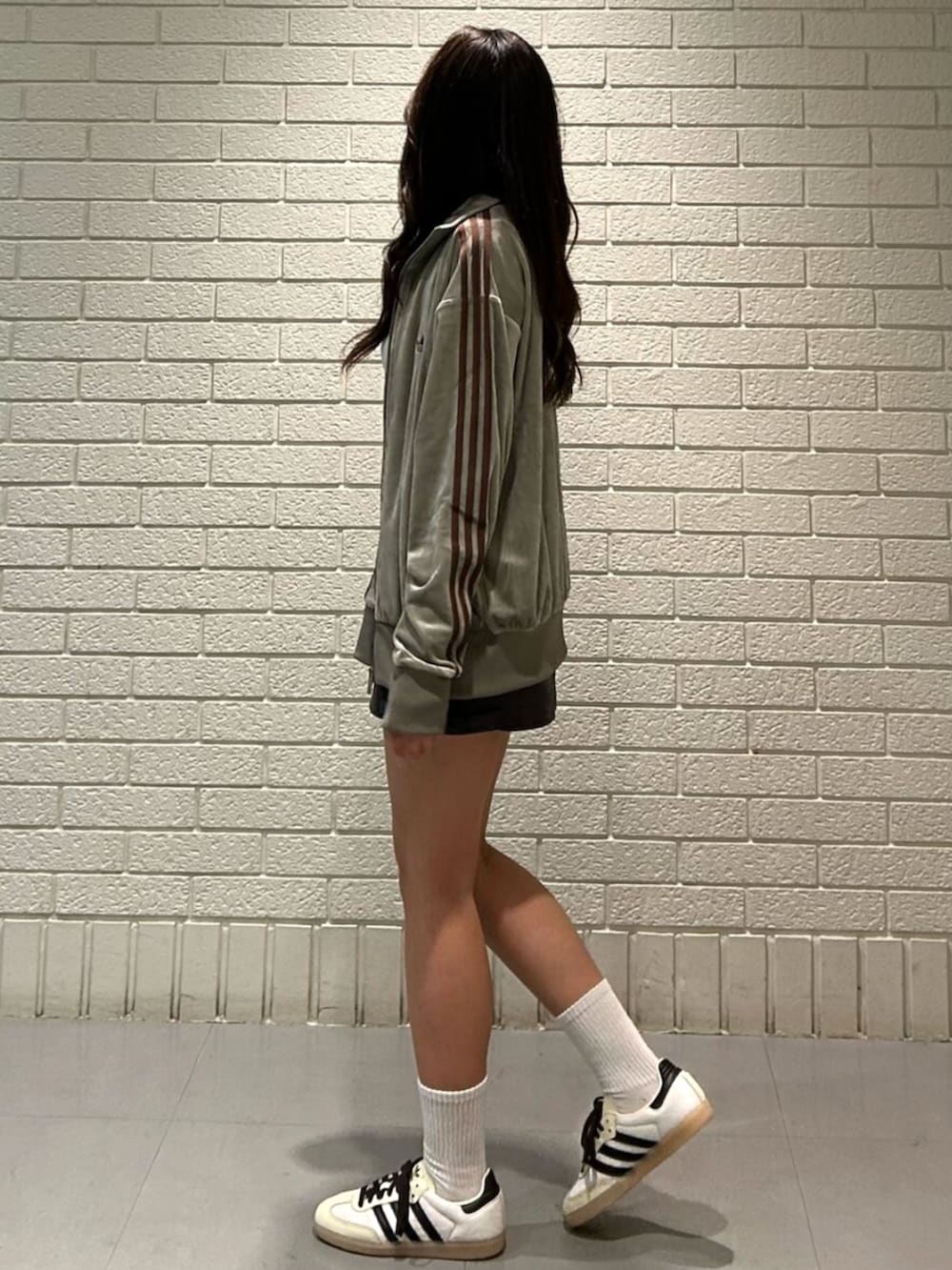 ベージュ系のジャージ、ホワイト系のスニーカーを着用したレディースの秋コーディネートの2枚目の写真