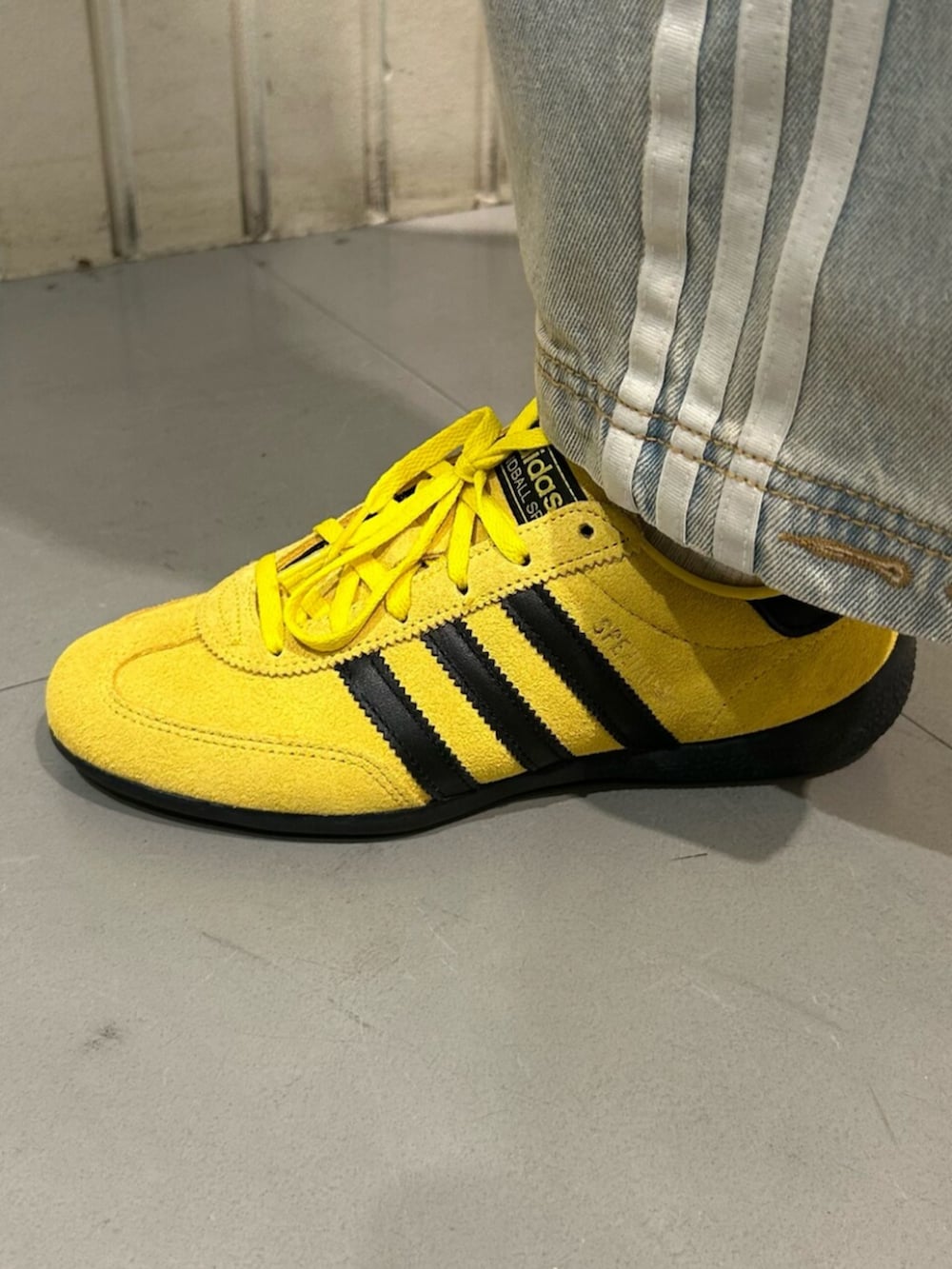 ブラック系のトップス、ブルー系のデニムパンツ、イエロー系のスニーカーを着用したレディースの冬コーディネートの4枚目の写真