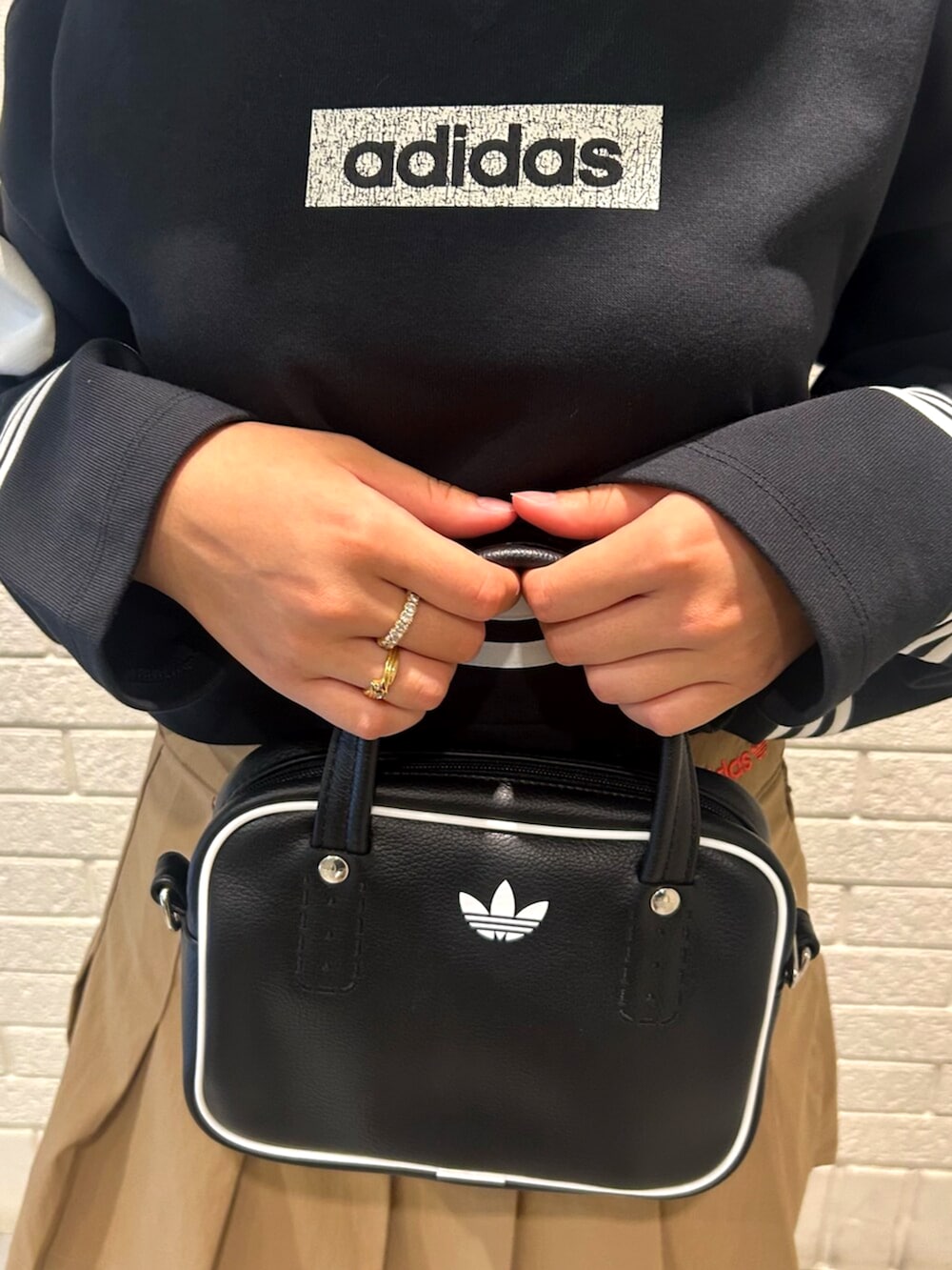 ブラック系のスウェット、ベージュ系のスカート、ブラック系のショルダーバッグを着用したレディースの夏コーディネートの3枚目の写真