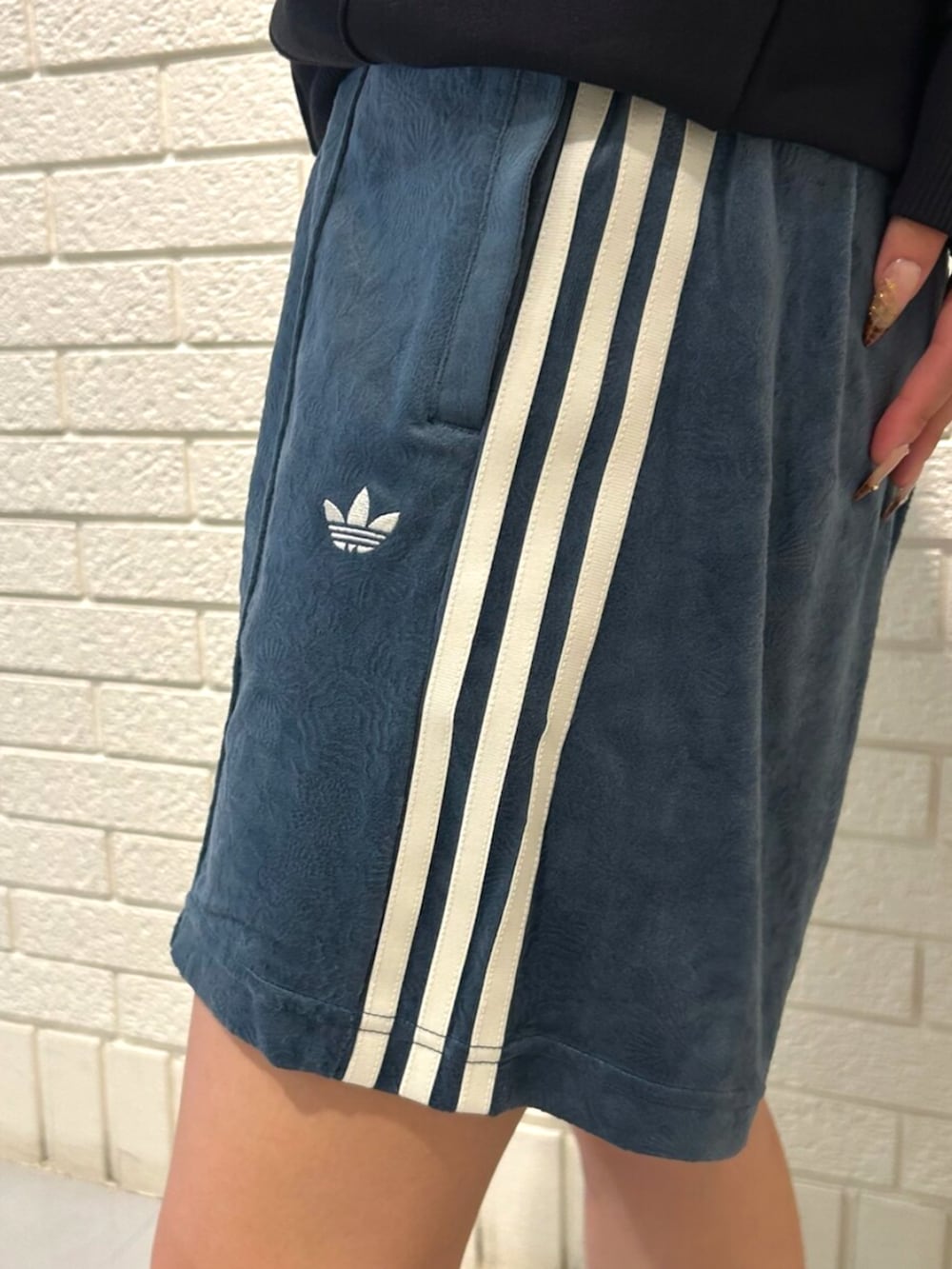 ブラック系のパーカー、ブラック系のスニーカー、グリーン系のその他パンツを着用したレディースの秋コーディネートの3枚目の写真