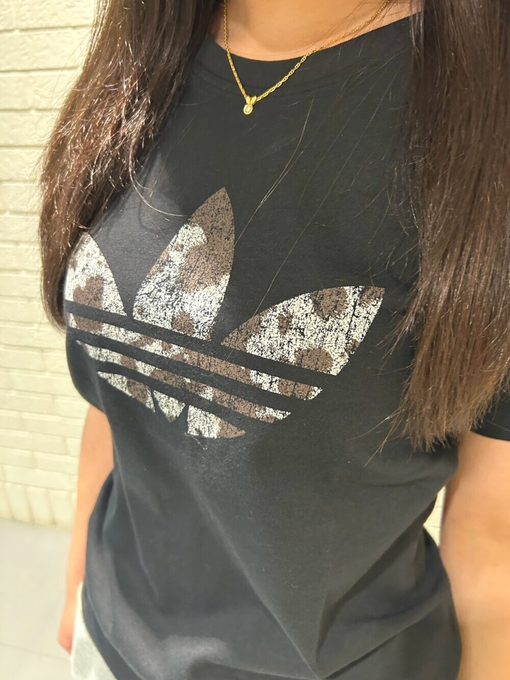 ホワイト系のシューズ、ブラック系のトップス、グリーン系のショルダーバッグを着用したレディースの春コーディネートの3枚目の写真