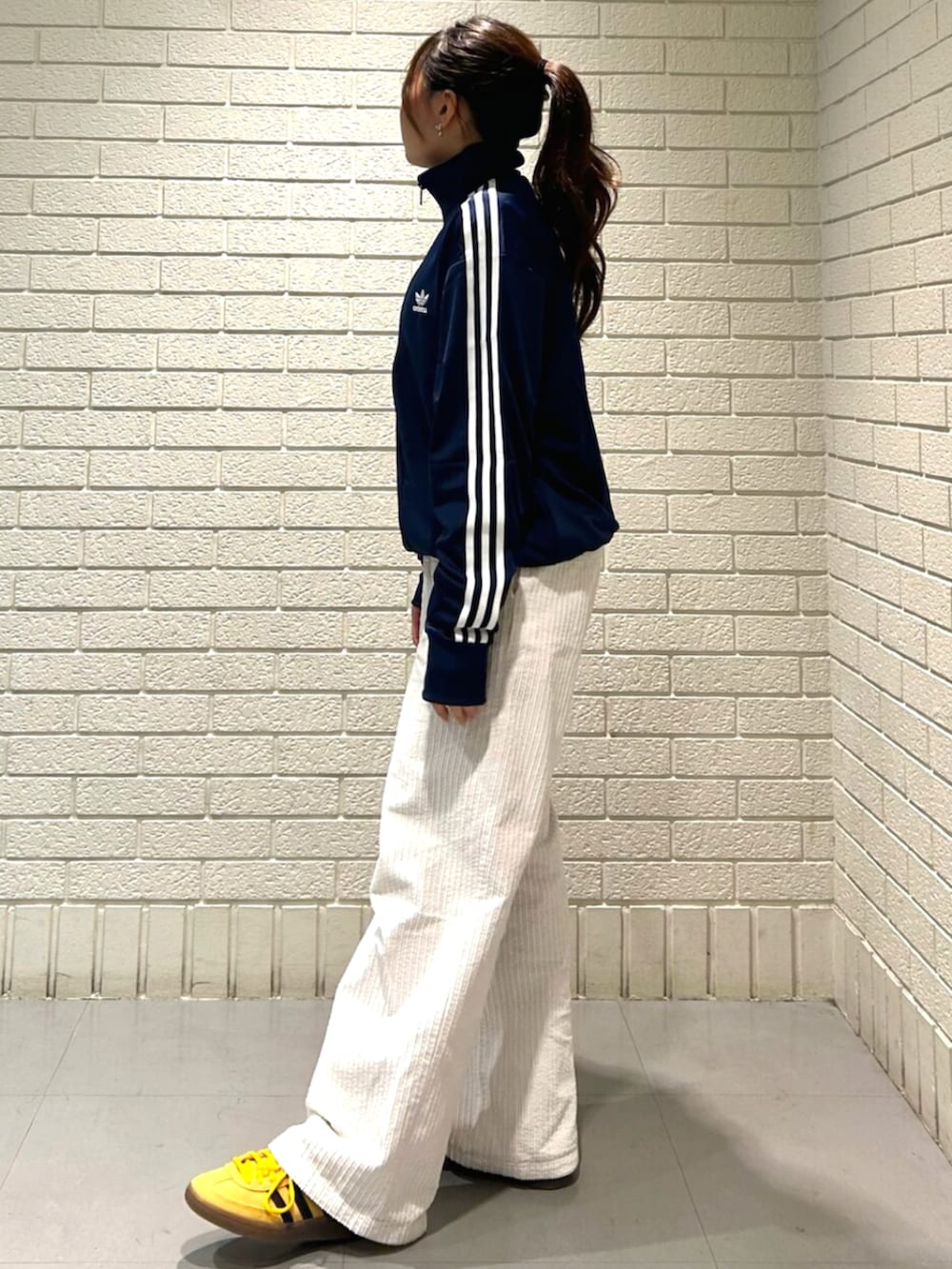 ブルー系のジャージ、イエロー系のスニーカーを着用したレディースの冬コーディネートの2枚目の写真