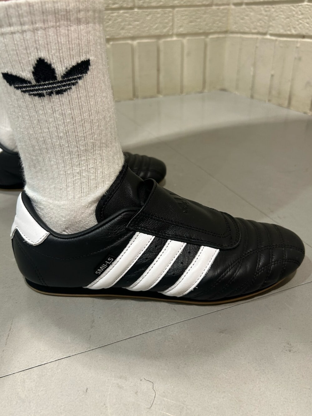 ブラック系のシューズ、ホワイト系のTシャツ/カットソー、ブラック系のハンドバッグを着用したレディースの夏コーディネートの2枚目の写真