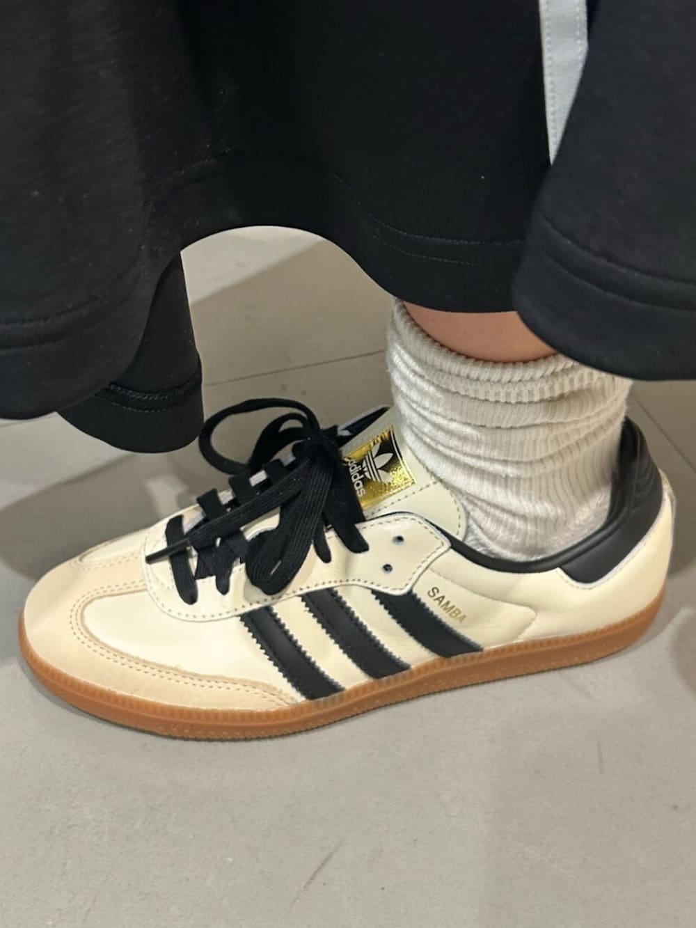 ホワイト系のスニーカー、ホワイト系のジャージ、ブラック系のスカートを着用したレディースの冬コーディネートの4枚目の写真