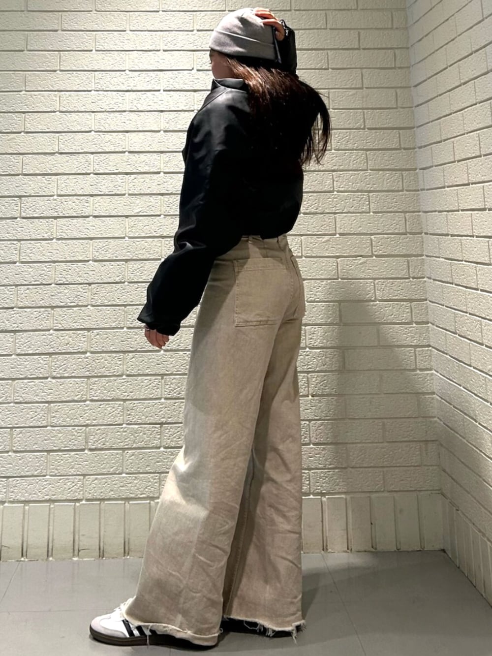 ホワイト系のシューズ、ブラック系のダウンジャケット/コートを着用したレディースの秋コーディネートの2枚目の写真