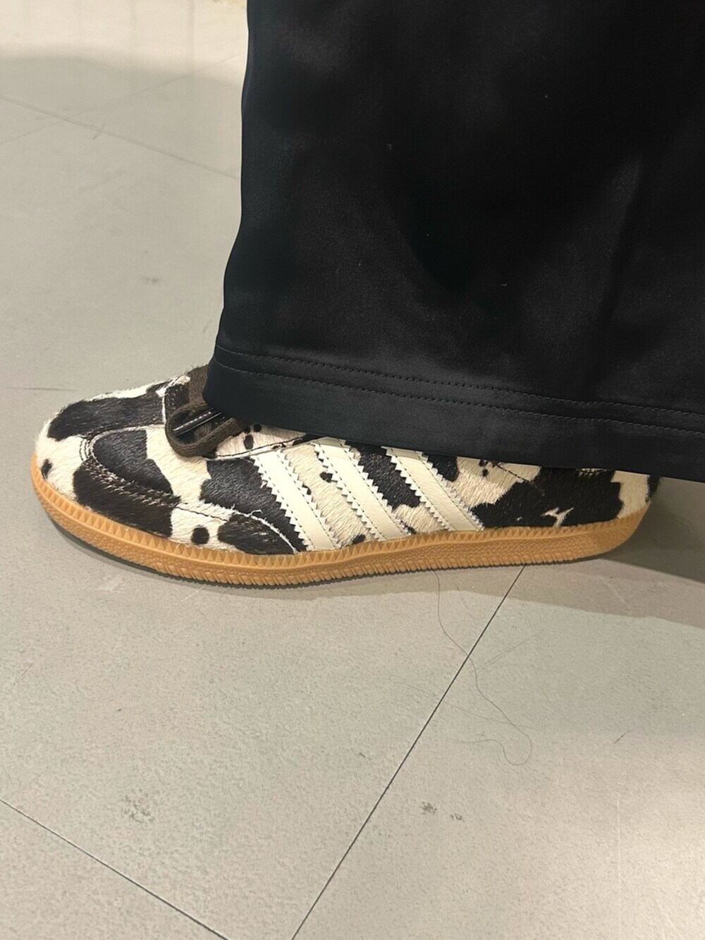 ブルー系のデニムジャケット、ブラック系のスウェットパンツ、ブラウン系のスニーカーを着用したレディースの秋コーディネートの4枚目の写真