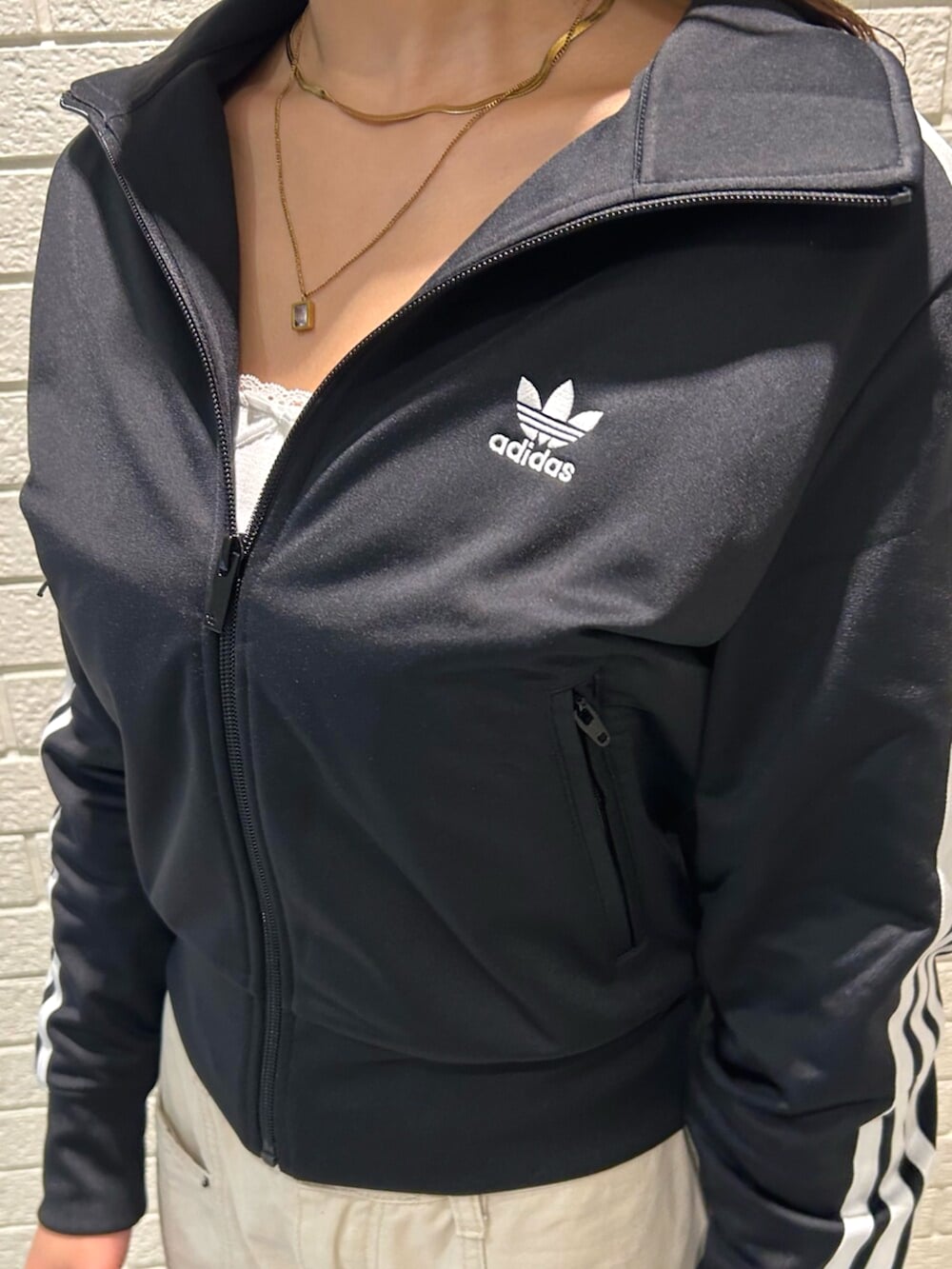 ブラック系のショルダーバッグ、ブラック系のジャージ、ホワイト系のシューズを着用したレディースの秋コーディネートの3枚目の写真