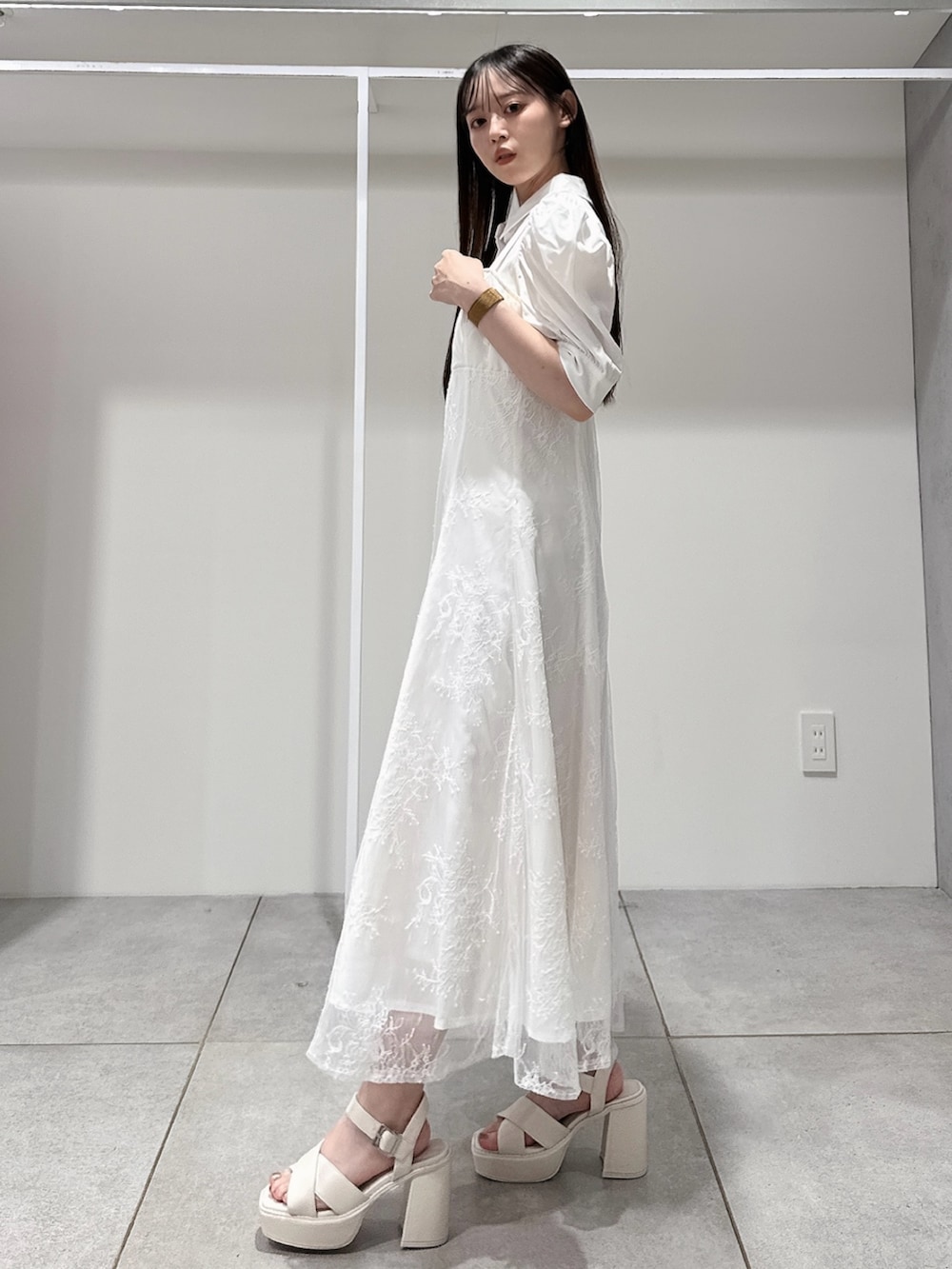 ホワイト系のワンピース、シルバー系のボディバッグ/ウエストポーチ、ホワイト系のサンダルを着用したレディースの夏コーディネートの4枚目の写真