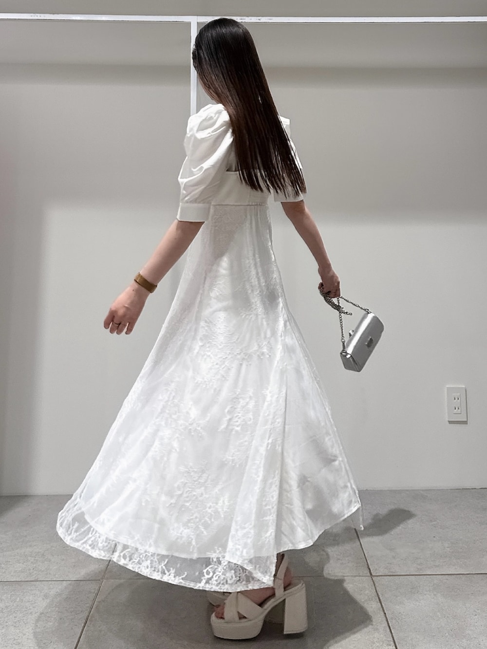 ホワイト系のワンピース、シルバー系のボディバッグ/ウエストポーチ、ホワイト系のサンダルを着用したレディースの夏コーディネートの7枚目の写真