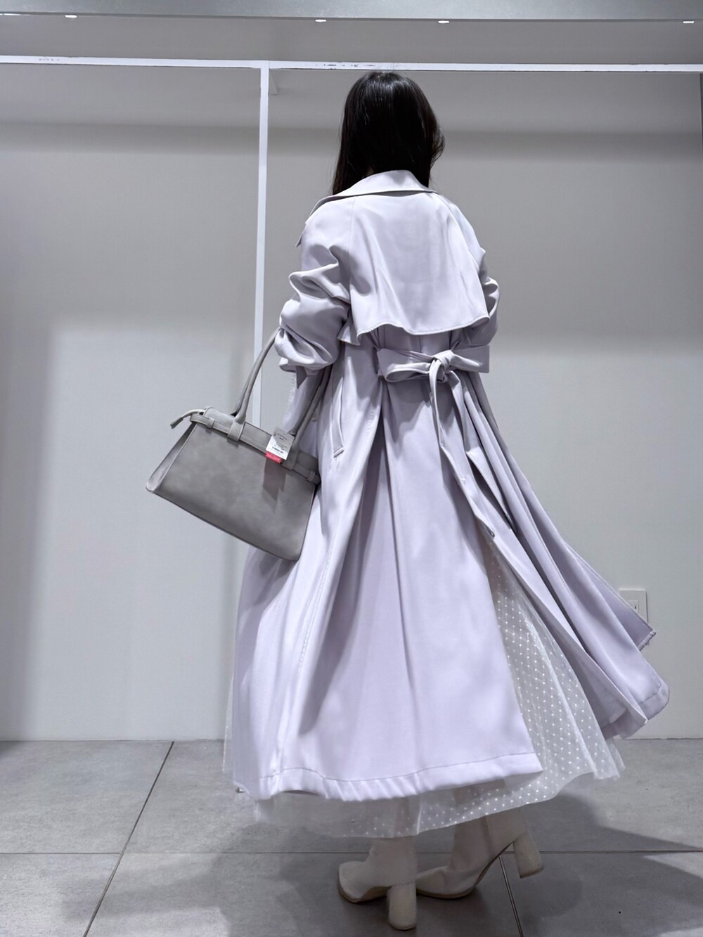 パープル系のトレンチコート、ホワイト系のワンピース、グレー系のハンドバッグを着用したレディースの冬コーディネートの5枚目の写真