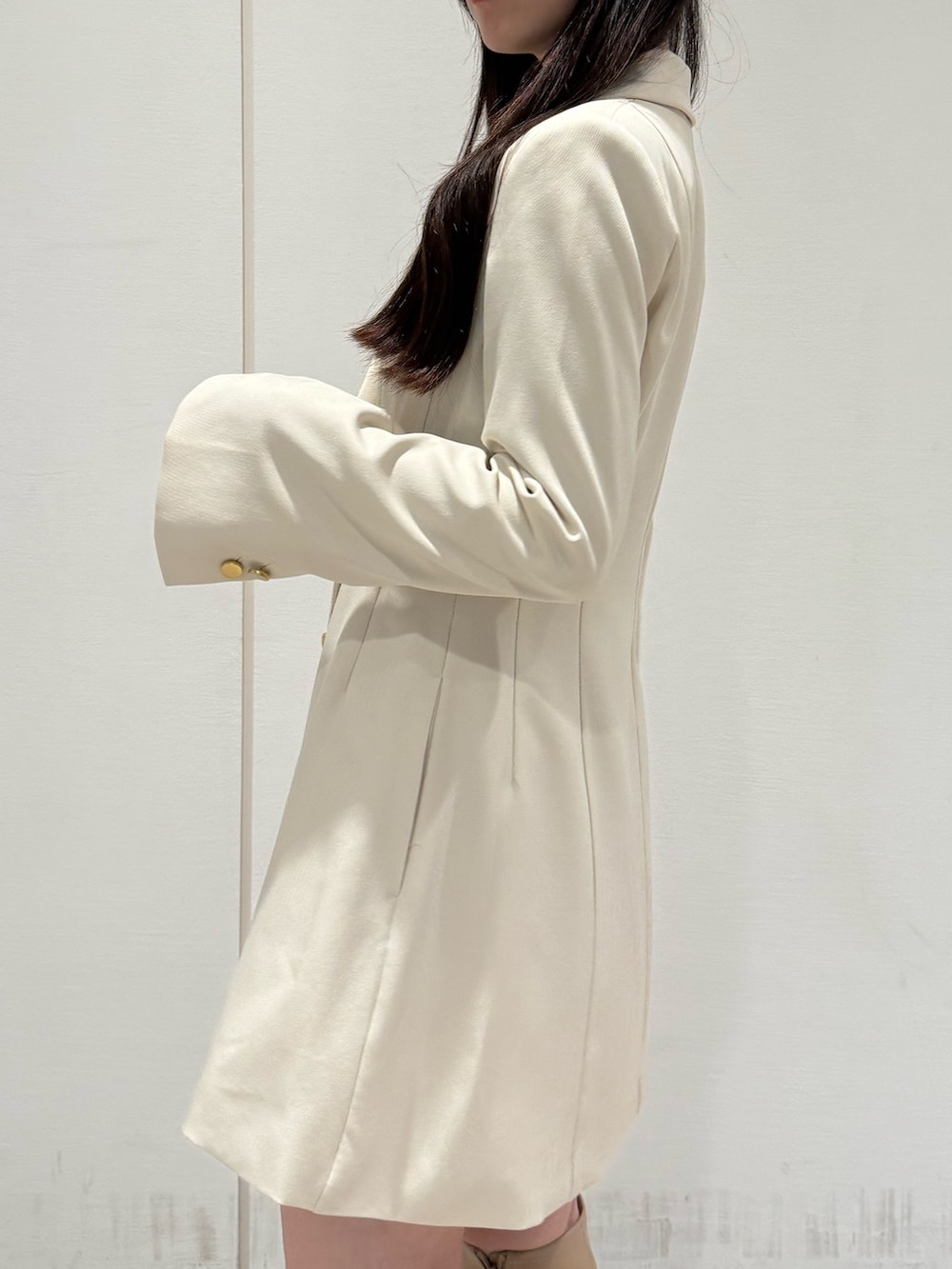 ホワイト系のワンピース、ベージュ系のブーツを着用したレディースの夏コーディネートの5枚目の写真