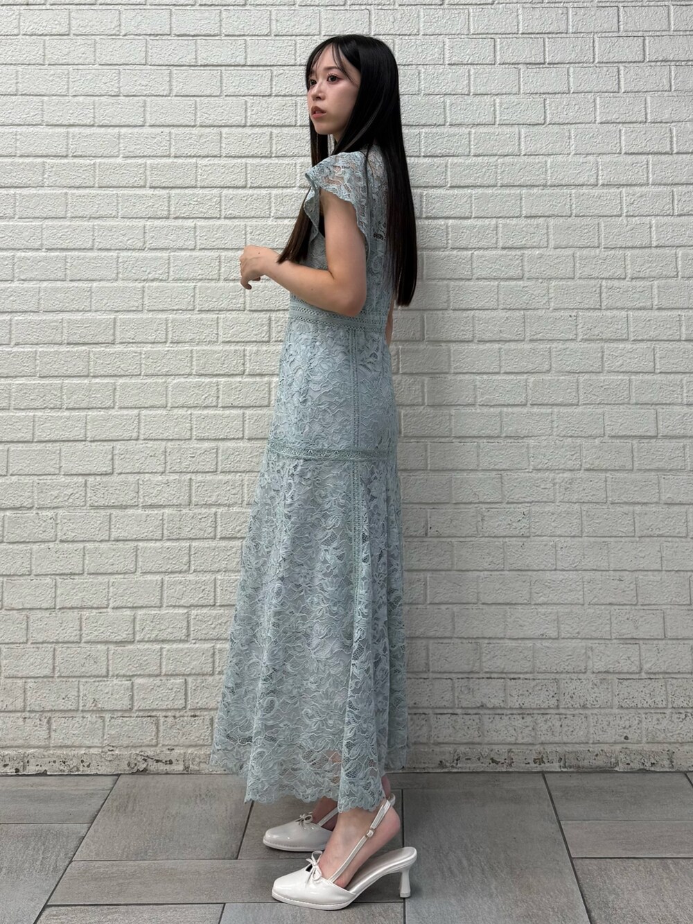 グリーン系のドレス、ホワイト系のパンプスを着用したレディースの秋コーディネートの3枚目の写真