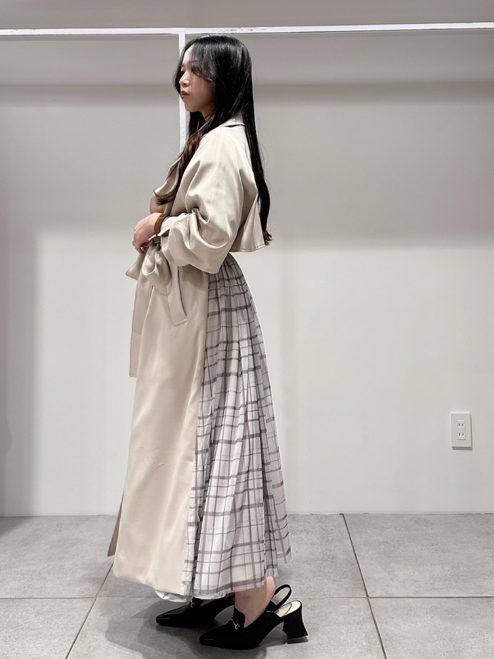 ベージュ系のトレンチコート、ブラウン系のハンドバッグ、ブラウン系のパンプスを着用したレディースの冬コーディネートの2枚目の写真