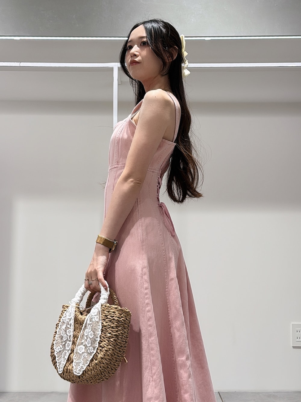 ピンク系のワンピース、ホワイト系のパンプス、ベージュ系のハンドバッグを着用したレディースの春コーディネートの5枚目の写真
