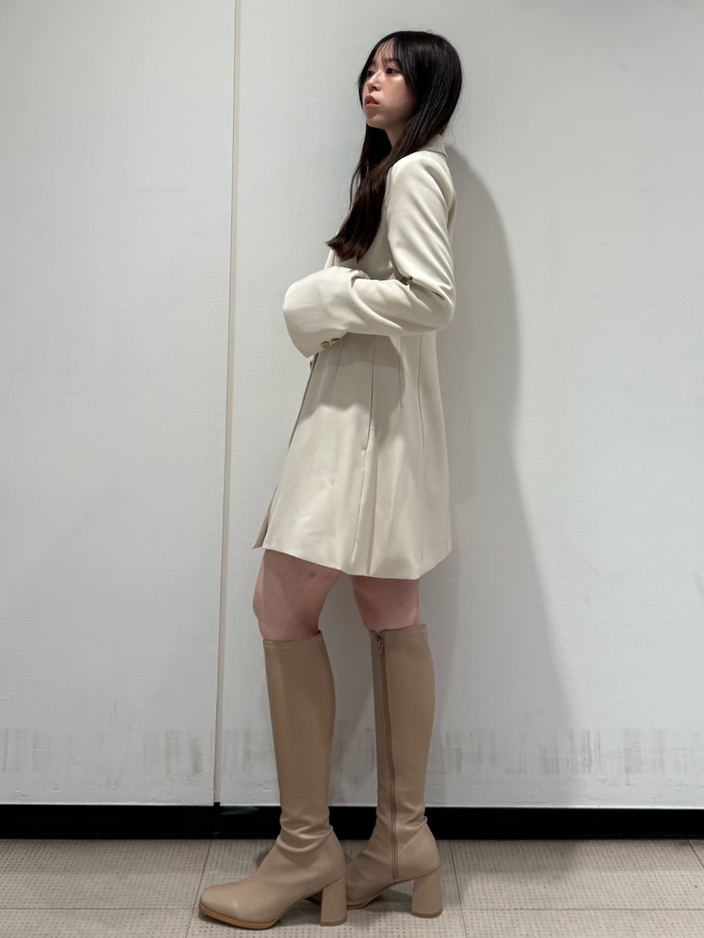 ホワイト系のワンピース、ベージュ系のブーツを着用したレディースの夏コーディネートの2枚目の写真