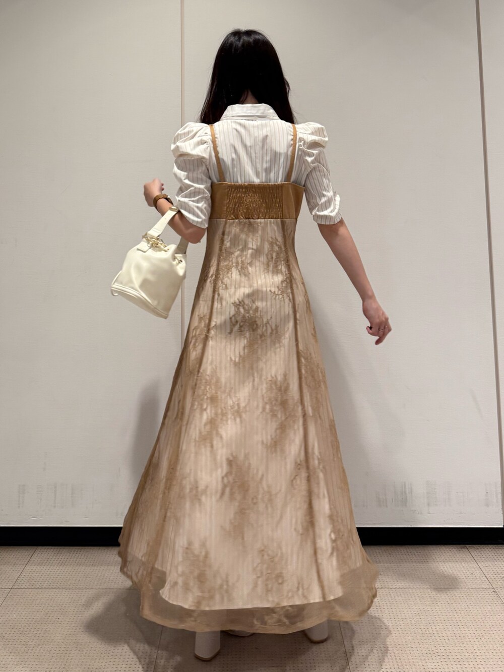 ベージュ系のワンピース、ホワイト系のハンドバッグ、ホワイト系のブーツを着用したレディースの夏コーディネートの3枚目の写真